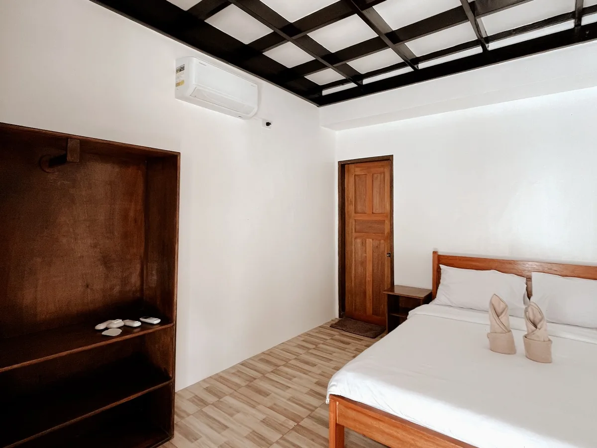 Double Room interior with white bedding, wooden shelving and exposed dark ceiling beams.