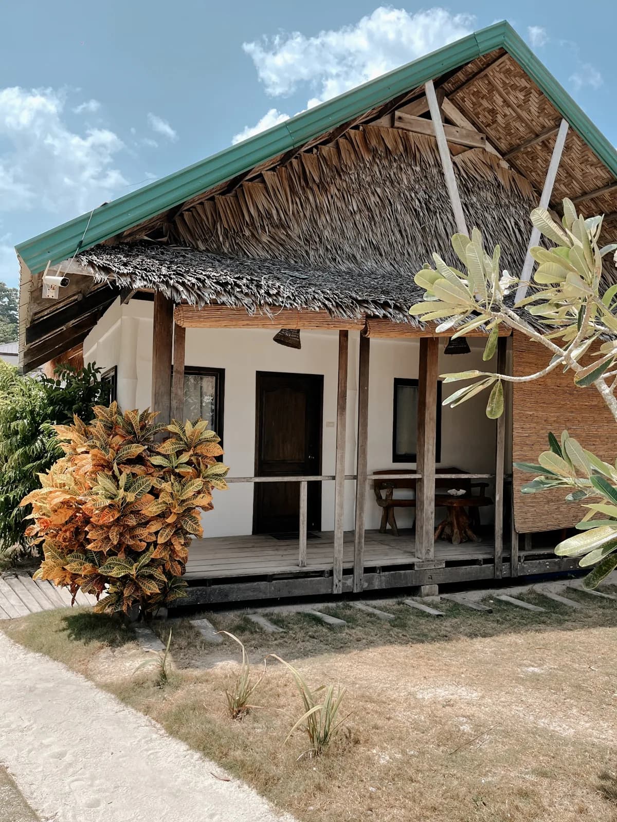 Exterior of the Beachfront Bungalow with its covered terrace and tropical planting.